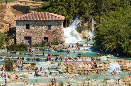 Saturnia, Grosseto, Italy, july 2021. Large group of people bathing in the natural thermal waters in Saturnia thermal waterfallsのeditorial素材