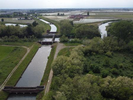 Wide drone view of Canale Cavour weaving through Novara's countryside, vital to Piedmont's vast agricultural irrigation network.の写真素材