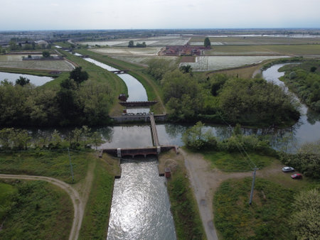 Wide drone view of Canale Cavour weaving through Novara's countryside, vital to Piedmont's vast agricultural irrigation network.の写真素材