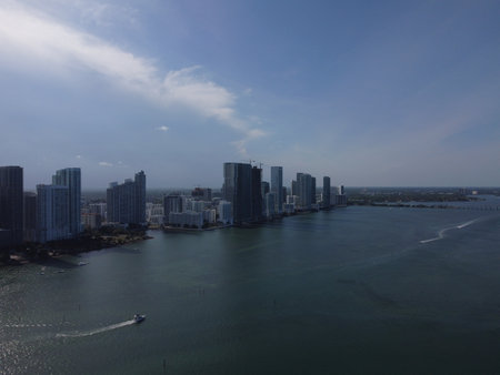 Wide daytime drone photo of Biscayne Bay facing Midtown and Downtown Miami, with skyline and blue waters under clear skies.の写真素材