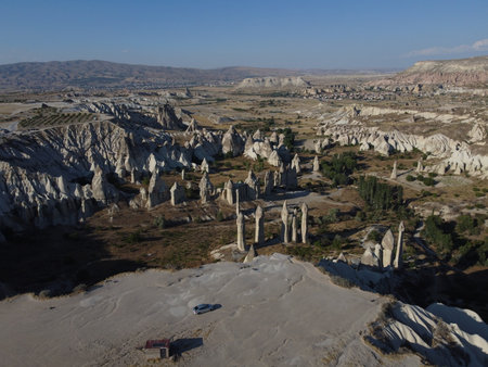 A stunning drone shot over Love Valley in Cappadocia, showcasing its iconic rock formations, surreal landscape, and warm tones under a clear sky.の写真素材