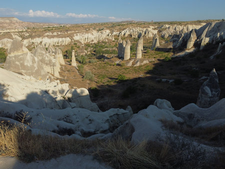 A stunning drone shot over Love Valley in Cappadocia, showcasing its iconic rock formations, surreal landscape, and warm tones under a clear sky.の写真素材