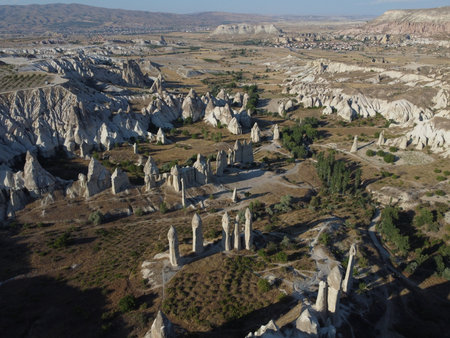 A stunning drone shot over Love Valley in Cappadocia, showcasing its iconic rock formations, surreal landscape, and warm tones under a clear sky.の写真素材