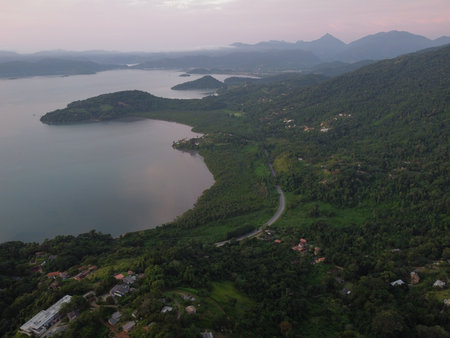 Sunset drone video over Paraty, Brazil, reveals lush Atlantic Forest, golden skies, and small islands scattered along the glowing coastline.の写真素材