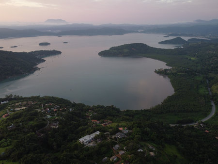 Sunset drone video over Paraty, Brazil, reveals lush Atlantic Forest, golden skies, and small islands scattered along the glowing coastline.の写真素材
