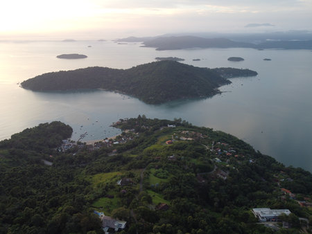 Sunset drone video over Paraty, Brazil, reveals lush Atlantic Forest, golden skies, and small islands scattered along the glowing coastline.の写真素材