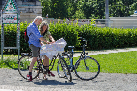 Berlin, Germany, June 6, 2018 - Active seniors on bikes looking at map on the streets of Berlin.のeditorial素材