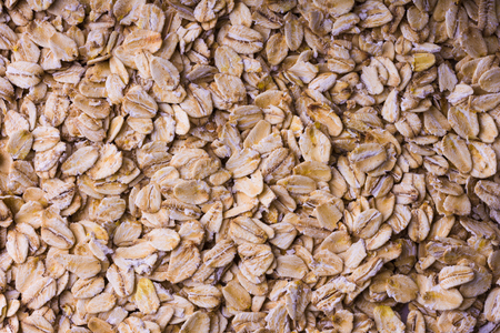 Background of oatmeal. Scattered rolled oats. Close up.の写真素材