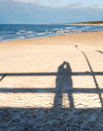 Shadow of a hugging couple on a beachの写真素材