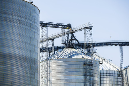 Huge, silver, shiny agricultural silos.