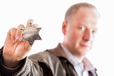 Sheriff presents his sheriff star badge isolated on whiteの写真素材