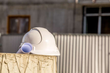 Blueprints and white helmet ready to use on construction siteの写真素材