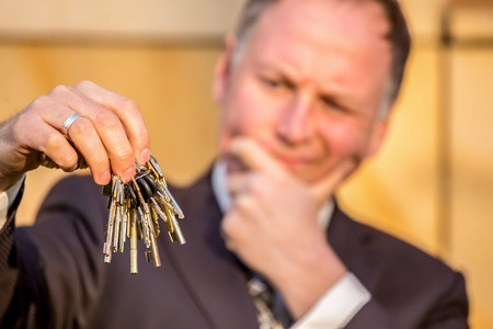 Businessman choosing the right key among bunchの写真素材