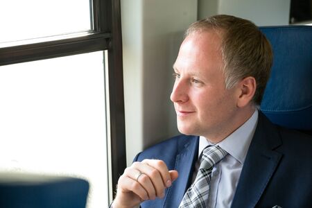 Businessman enjoying his trip sitting comfortably in train