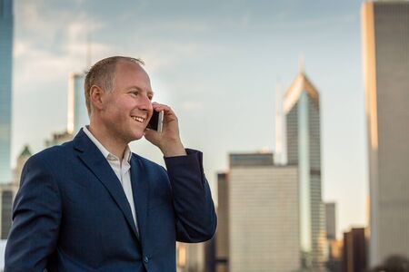 Businessman using mobile phone outside the officesの写真素材