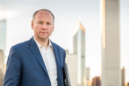 Businessman with laptop in front of skyscrapers