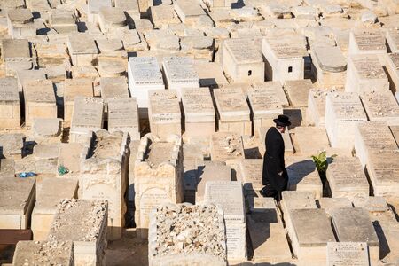 Jerusalem, Israel - November 1, 2015: Orthodox Jew walking among graves on the Mount of Olives cemetery.のeditorial素材