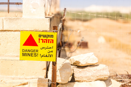 Danger Mines! Warning sign and barbed wire. Israeli border with Jordan