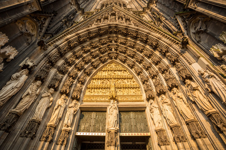 Sculptures around main door to gothic cathedral in Koln, Germany, Europeの写真素材