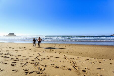 Surfers on wild beach in Algarve, western Portugal