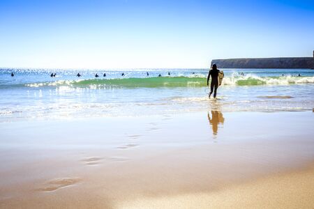 Surfers on Beliche Beach, Mediterranean Sea, Portugalの写真素材