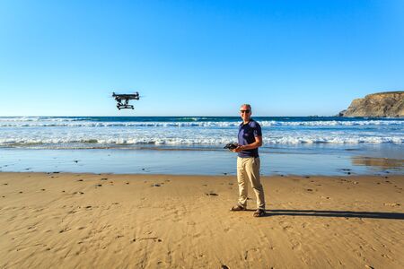 Photographer with a drone on beautiful wild beachの写真素材