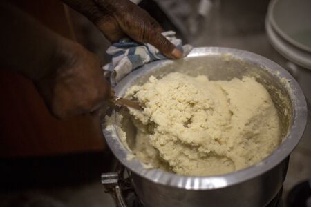 African woman preparing common ugali made from maize flourの写真素材