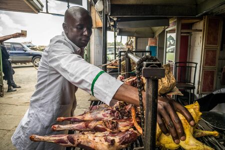 Nairobi, Kenya - December 2, 2016: Chief cook preparing nyama choma - traditional east african grilled meatのeditorial素材