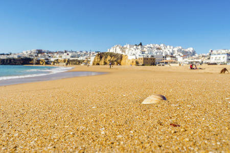 Shells on wide, sandy beach in white city of Albufeira by Atlantic Ocean, Algarve, Portugalの写真素材