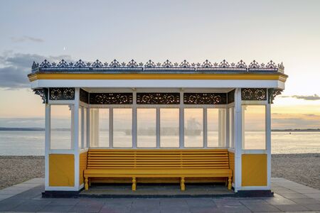 Beautiful yellow vintage bus stop by the sea in Portsmouth, Great Britainの写真素材