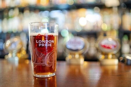 Portsmouth, United Kingdom - November 2, 2019: Glass of cold London Pride beer served in British pubのeditorial素材