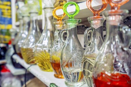 Variety of oils in glass bottles displayed on shelf in medina of Marrakech, Moroccoの写真素材