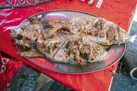 Two barbecued fish served on a silver tray, Mozambique