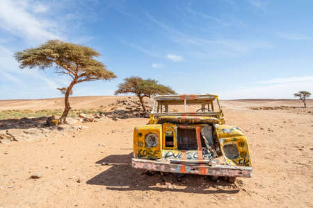 Yellow wrecked car car abandoned on Sahara desert in Morocco, Africaのeditorial素材