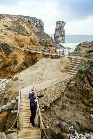 Father and little son admiring beautiful Papoa islet in Peniche, Leiria district, Portugal