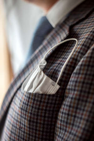 Elegant man with protective mask as handkerchief in chest pocket of his suitの写真素材