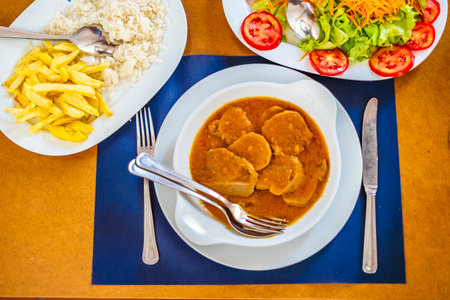 Traditional food from Alentejo - cow's tongue in a sauce served with salad, rice and french fries, Portugal, Europeの写真素材
