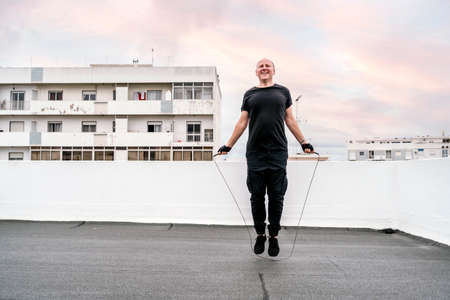 A man exercising on the rooftop using a jumping rope during the lockdown, Portugal