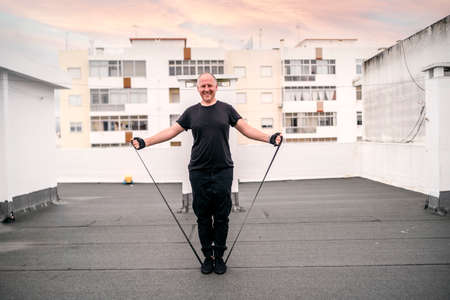A man exercising with gum on the rooftop during self-confinement caused by pandemicの写真素材