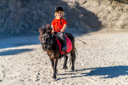Nerja, Spain - July 14, 2021: Dwarf girl Anika brilliantly riding pony horseのeditorial素材