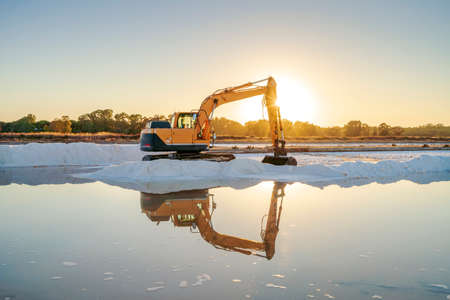 Sea salt harvest with yellow digger at salines in Faro, Algarve, Portugalの写真素材