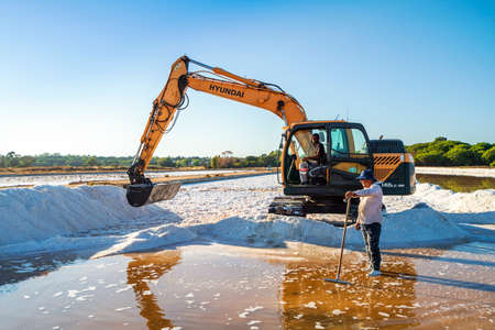 August 20, 2021 - Faro, Portugal: Sea salt harvest with a yellow digger at natural salines