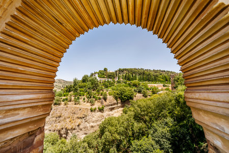 View of Generalife palace and garden through the Arabic arch in palace complex called Alhambra in Granada, Spainのeditorial素材