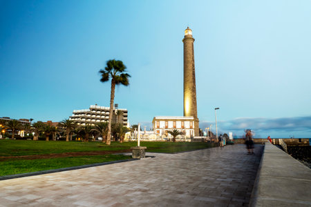 Lighthouse on rocky coast during sunset in Maspalomas, Gran Canaria, Spainの写真素材
