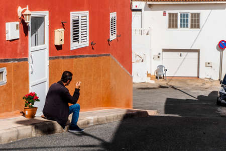 A local man smoking a cigarette sitting in front of his house in the street of Pozo Izquierdo,...