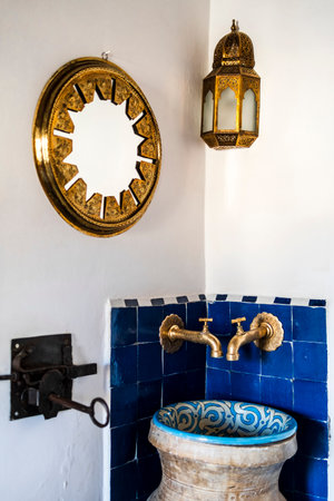 Traditional wash basin and golden mirror and lamp in the corner of the riad's bedroom, Medina of Fez, Morocco, North Africaの写真素材