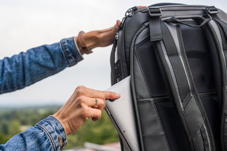 Woman packing a laptop in a backpack for a trip