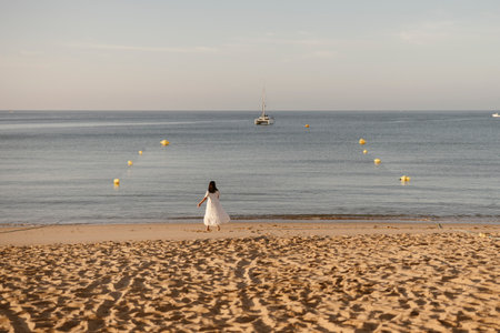 Luxury portrait of woman in white dress at the beach, Albufeira, Algarve, Portugalの写真素材