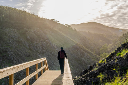 A man contemplating the beauty of the mointains from  boardwalk in Alferce, Algarve, Portugal