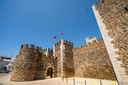 Medieval stone walls and towers of Beja Castle in Alentejo, Portugal, under a clear blue sky.の写真素材